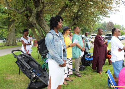 people standing under a tree at outdoor parish event